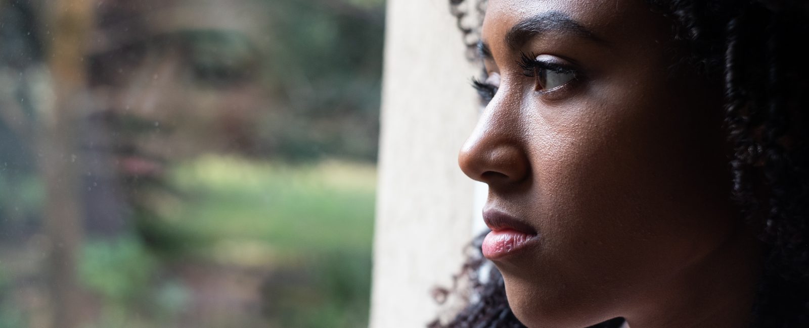 woman staring out window alone